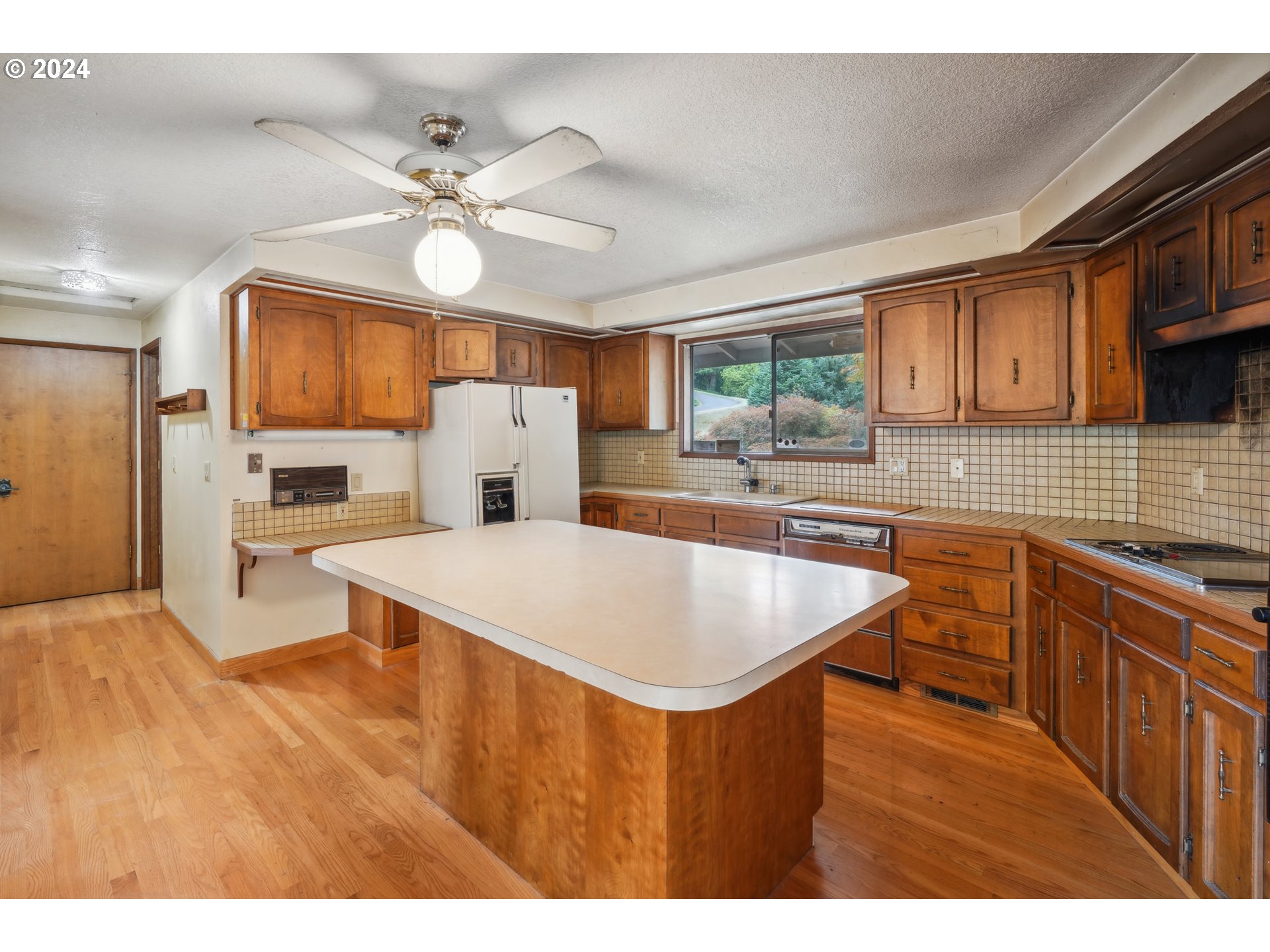 12795 Southeast Callahan Road Happy Valley, OR 97086 - Photo 13 of 42 a kitchen with kitchen island a stove a sink and a refrigerator