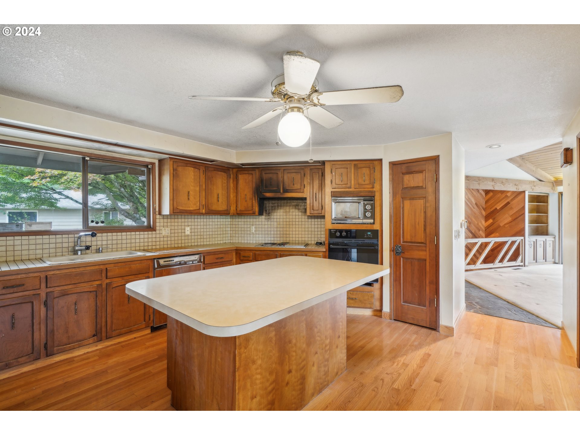 12795 Southeast Callahan Road Happy Valley, OR 97086 - Photo 14 of 42 a kitchen with a sink a counter top space stainless steel appliances and a large window