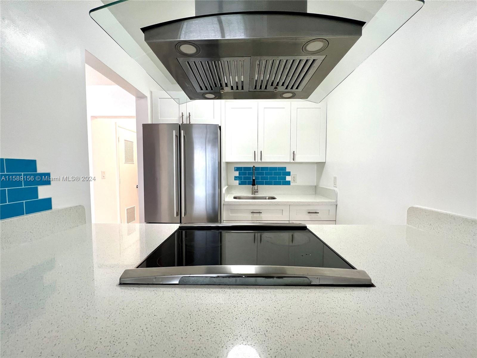 a kitchen with stainless steel appliances a sink a refrigerator and window