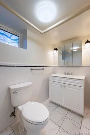 a bathroom with a toilet a sink and mirror