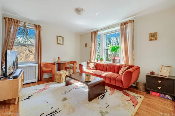 a living room with furniture fireplace and a large window