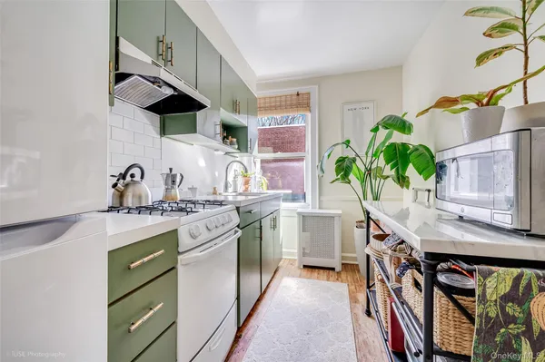 a kitchen with stainless steel appliances a sink a stove and a wooden floor