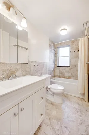 a bathroom with a granite countertop sink mirror vanity bathtub and a shower
