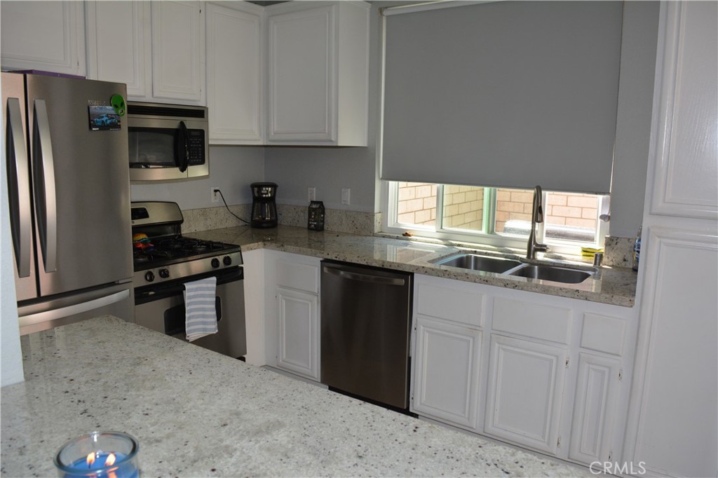 119 Draft Way Placentia, CA 92870 - Photo 9 of 24 a kitchen with granite countertop a refrigerator stove and sink