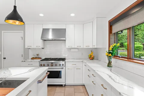 a kitchen with stainless steel appliances granite countertop a sink a stove a refrigerator and cabinets