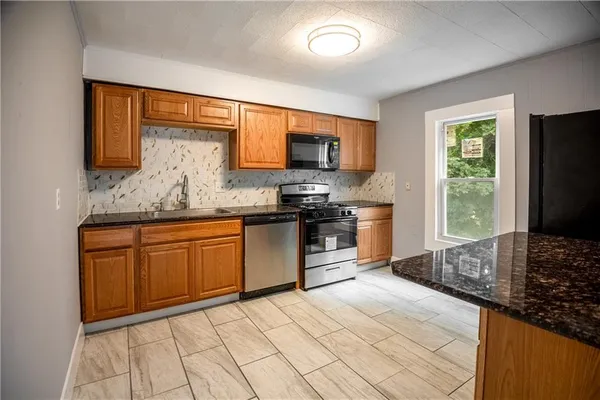 a kitchen with stainless steel appliances granite countertop a stove sink and microwave