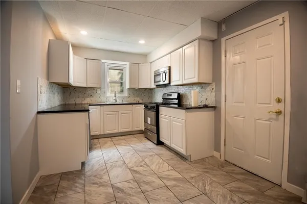 a kitchen with stainless steel appliances granite countertop a refrigerator sink and cabinets