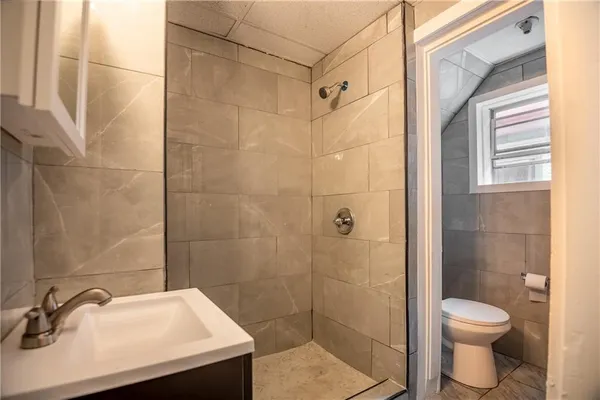 a bathroom with a sink a toilet and shower