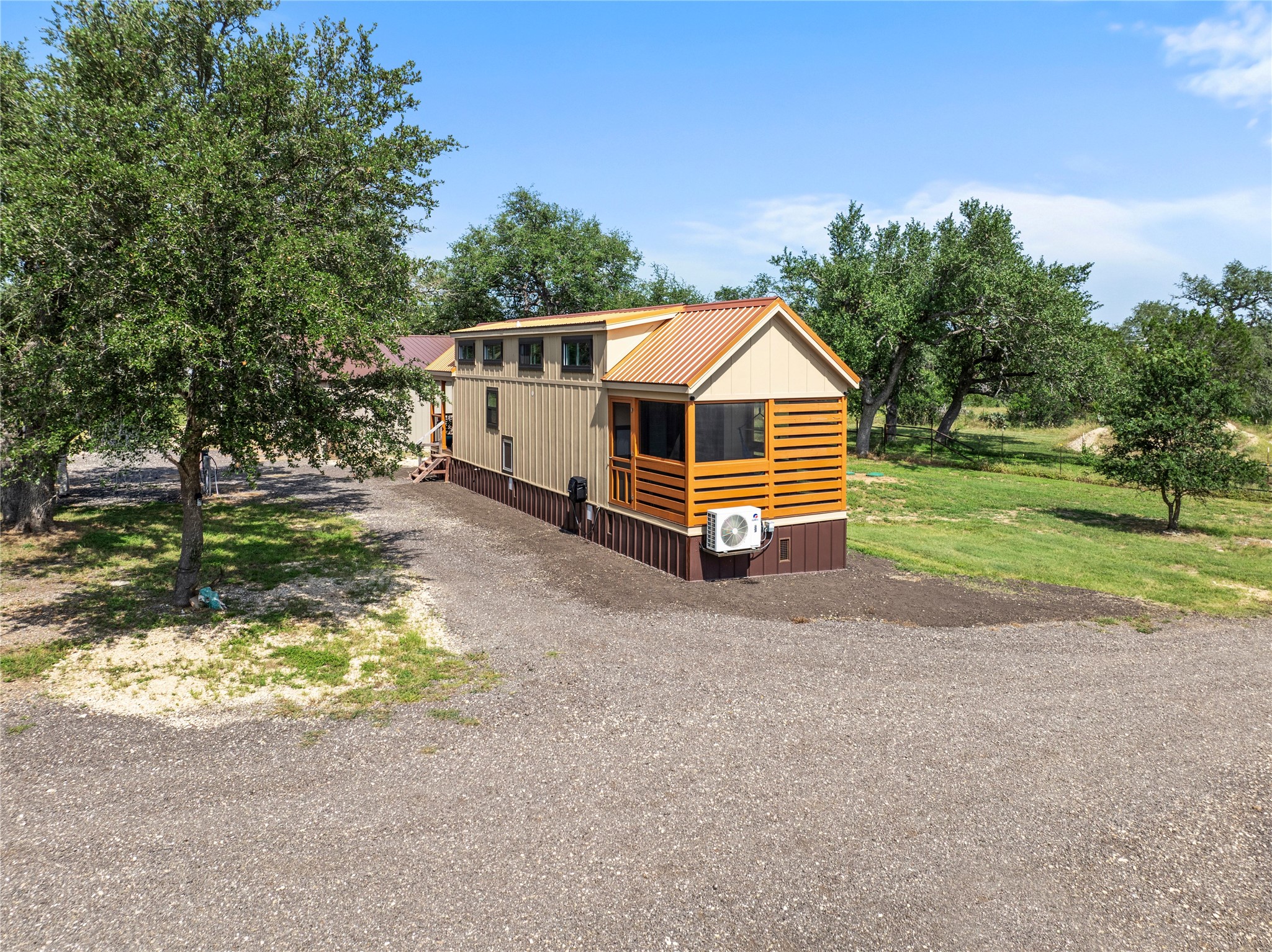 8200 Ranch Road 12 San Marcos, TX 78666 - Photo 9 of 40 A charming, compact residence featuring natural wood accents and a durable metal roof, nestled amidst mature trees.