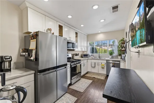 a kitchen with a refrigerator a sink and cabinets
