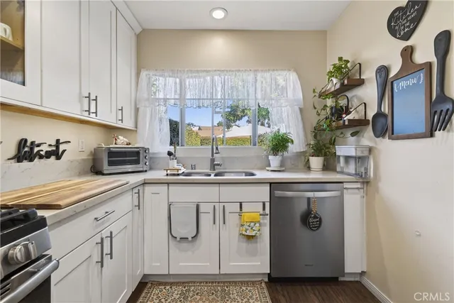 a kitchen with stainless steel appliances granite countertop a sink a stove and cabinets