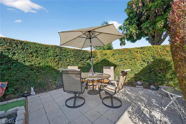 a view of a patio with chairs and table under an umbrella