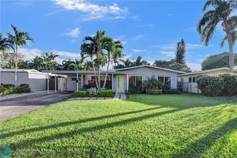 1548 Northeast 37th Street Oakland Park, FL 33334 - Photo 1 of 38 a front view of a house with a yard and potted plants