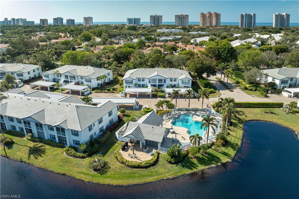 835 Tanbark Drive, Unit 203 Naples, FL 34108 - Photo 1 of 17 a view of a house with a big yard and large trees
