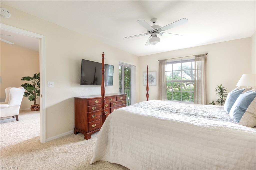 835 Tanbark Drive, Unit 203 Naples, FL 34108 - Photo 11 of 17 a bedroom with a bed television and a large window
