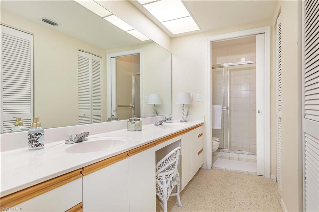 835 Tanbark Drive, Unit 203 Naples, FL 34108 - Photo 12 of 17 a bathroom with a double vanity sink and a mirror