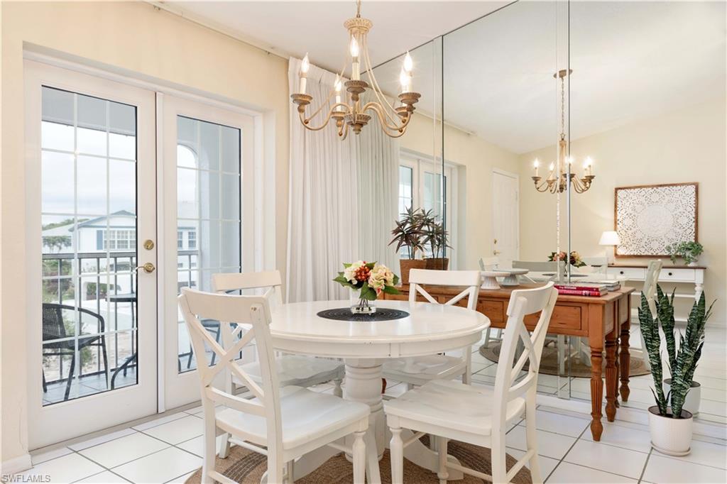 835 Tanbark Drive, Unit 203 Naples, FL 34108 - Photo 5 of 17 a dining room with furniture a chandelier and window