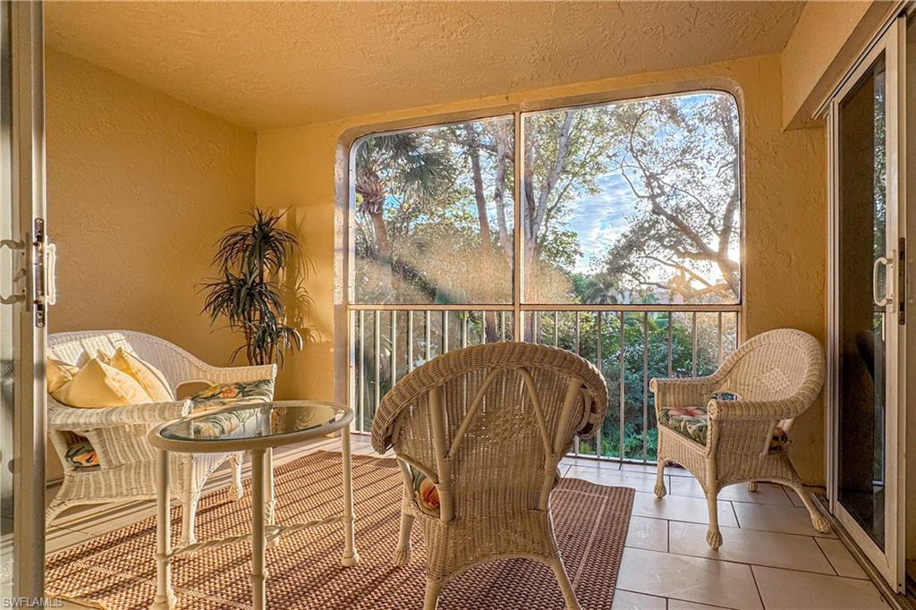 835 Tanbark Drive, Unit 203 Naples, FL 34108 - Photo 9 of 17 a balcony with table and chairs