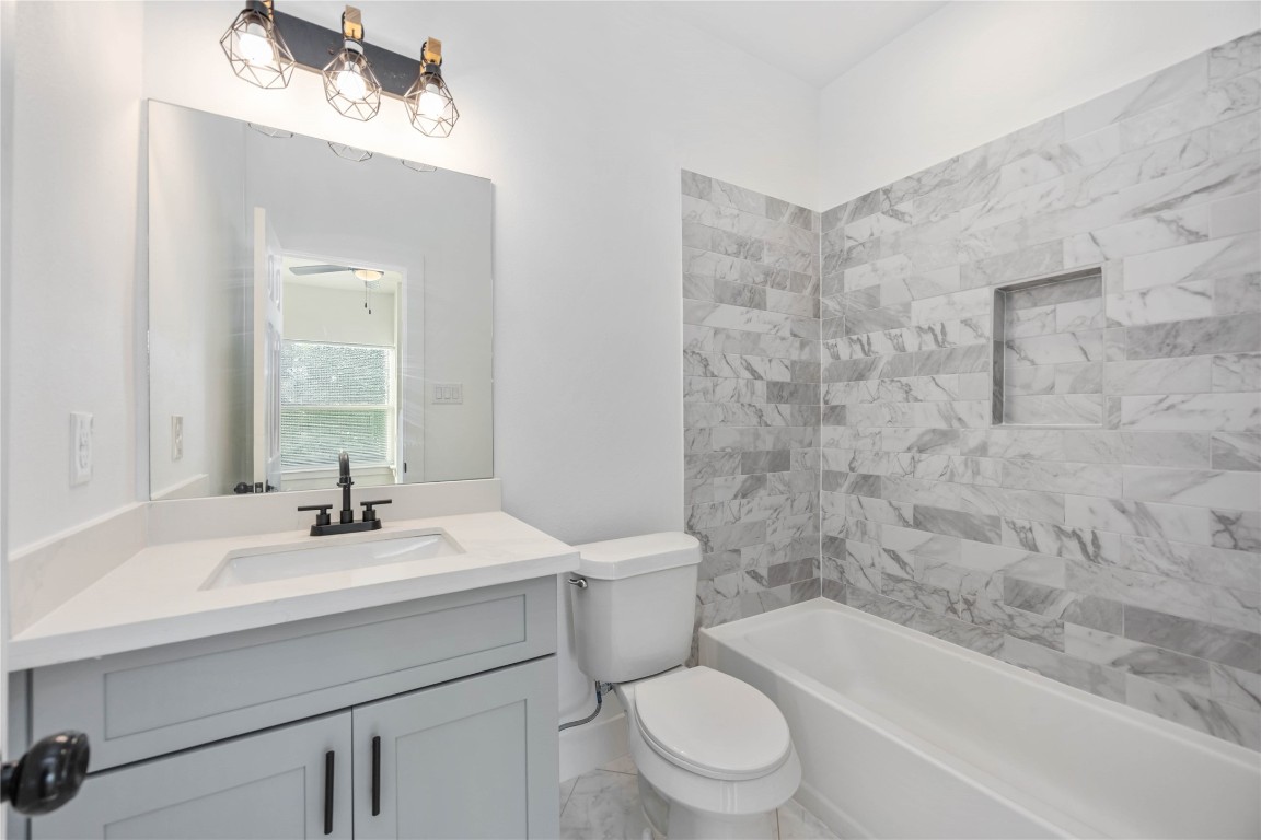 7710 Independence Street, Unit A Houston, TX 77051 - Photo 17 of 25 a bathroom with a sink a toilet and shower