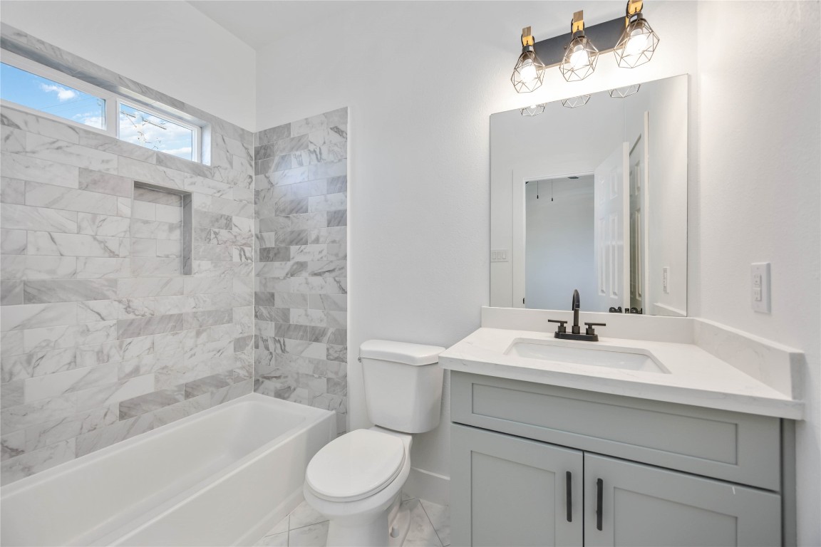 7710 Independence Street, Unit A Houston, TX 77051 - Photo 21 of 25 a bathroom with a sink a toilet a mirror a vanity and bathtub