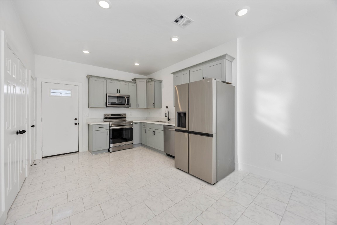7710 Independence Street, Unit A Houston, TX 77051 - Photo 6 of 25 a kitchen with stainless steel appliances a refrigerator and white cabinets