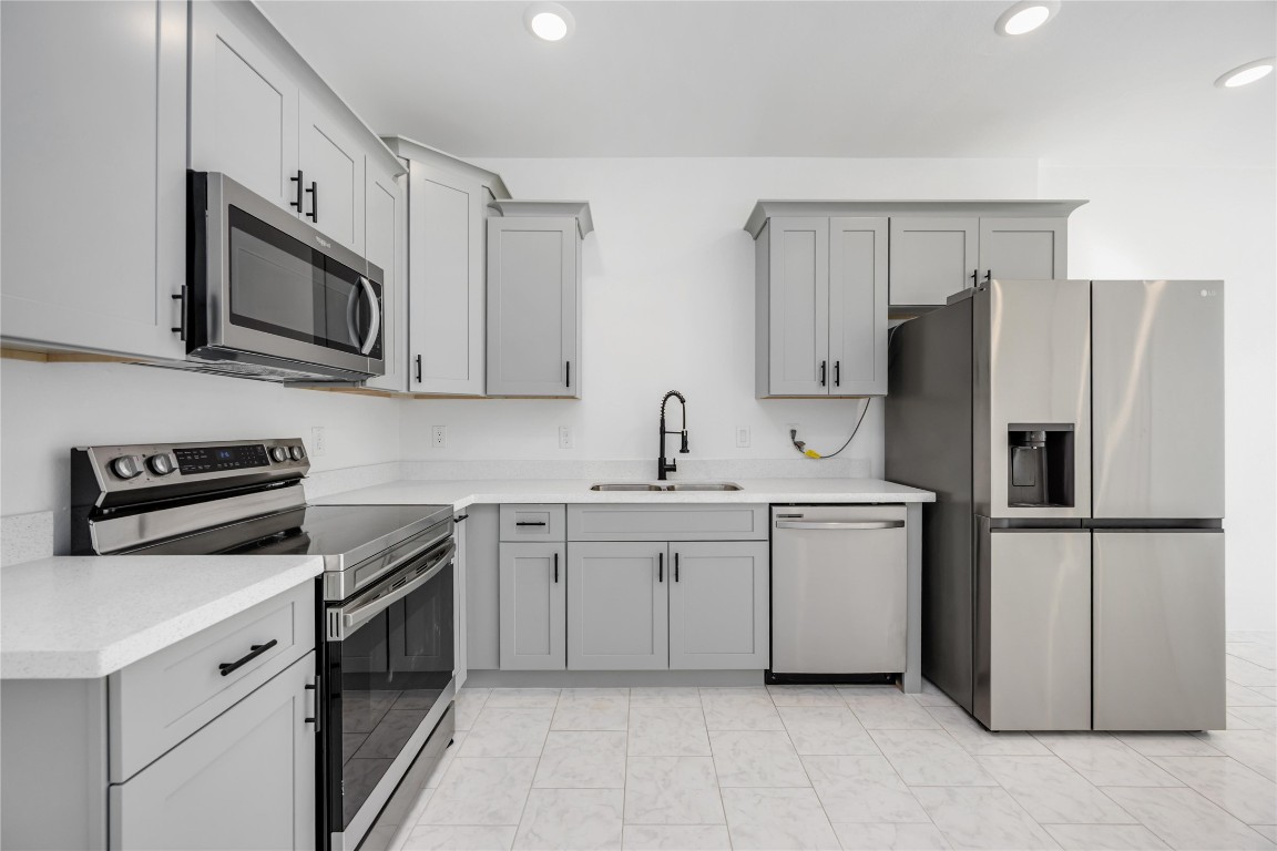 7710 Independence Street, Unit A Houston, TX 77051 - Photo 8 of 25 a kitchen with white cabinets and stainless steel appliances