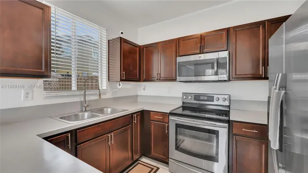 a kitchen with stainless steel appliances granite countertop a sink stove and microwave