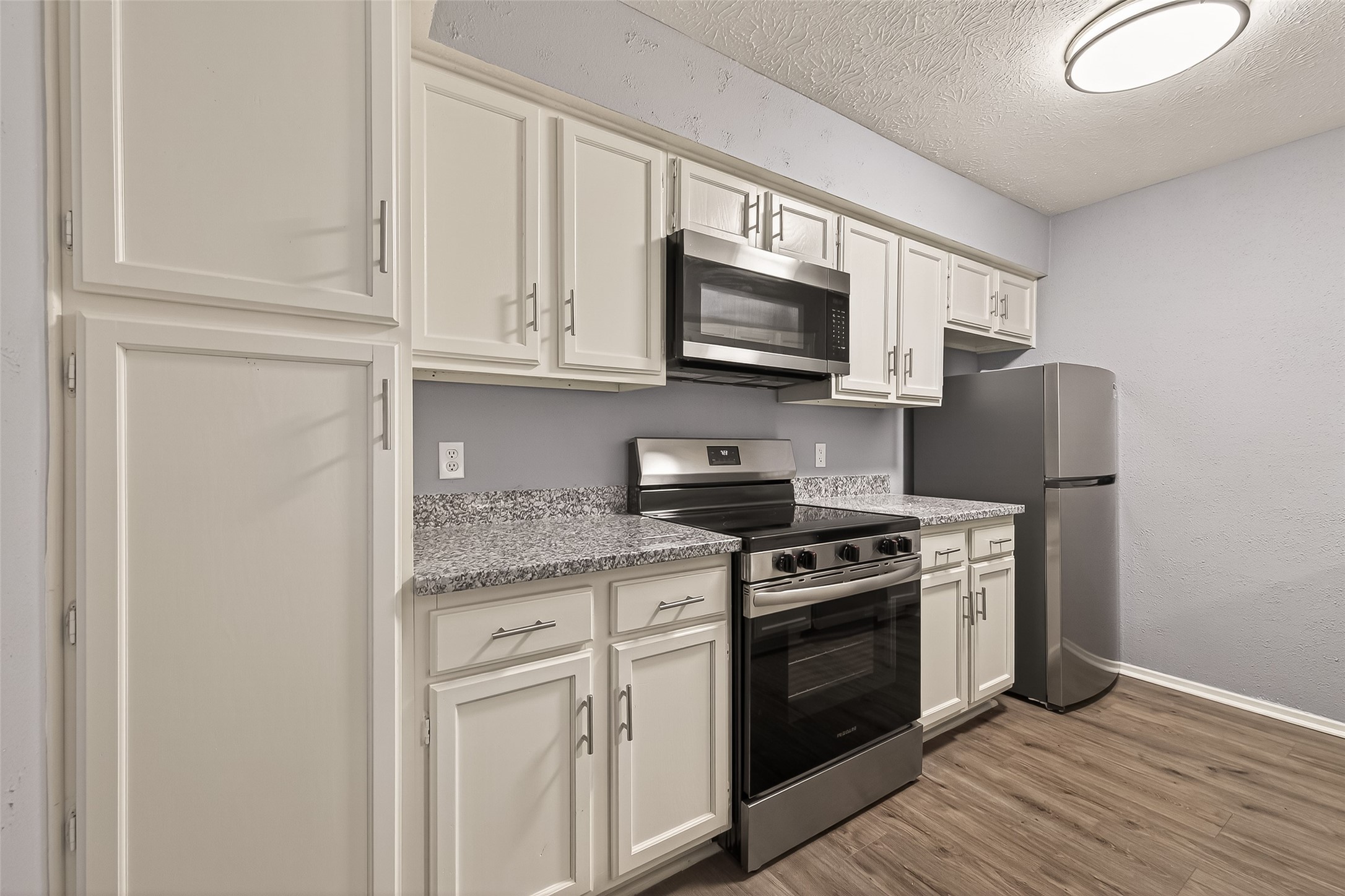 7313 Gulf Freeway, Unit 904 Houston, TX 77017 - Photo 14 of 27 a kitchen with stainless steel appliances granite countertop a stove top oven microwave and refrigerator