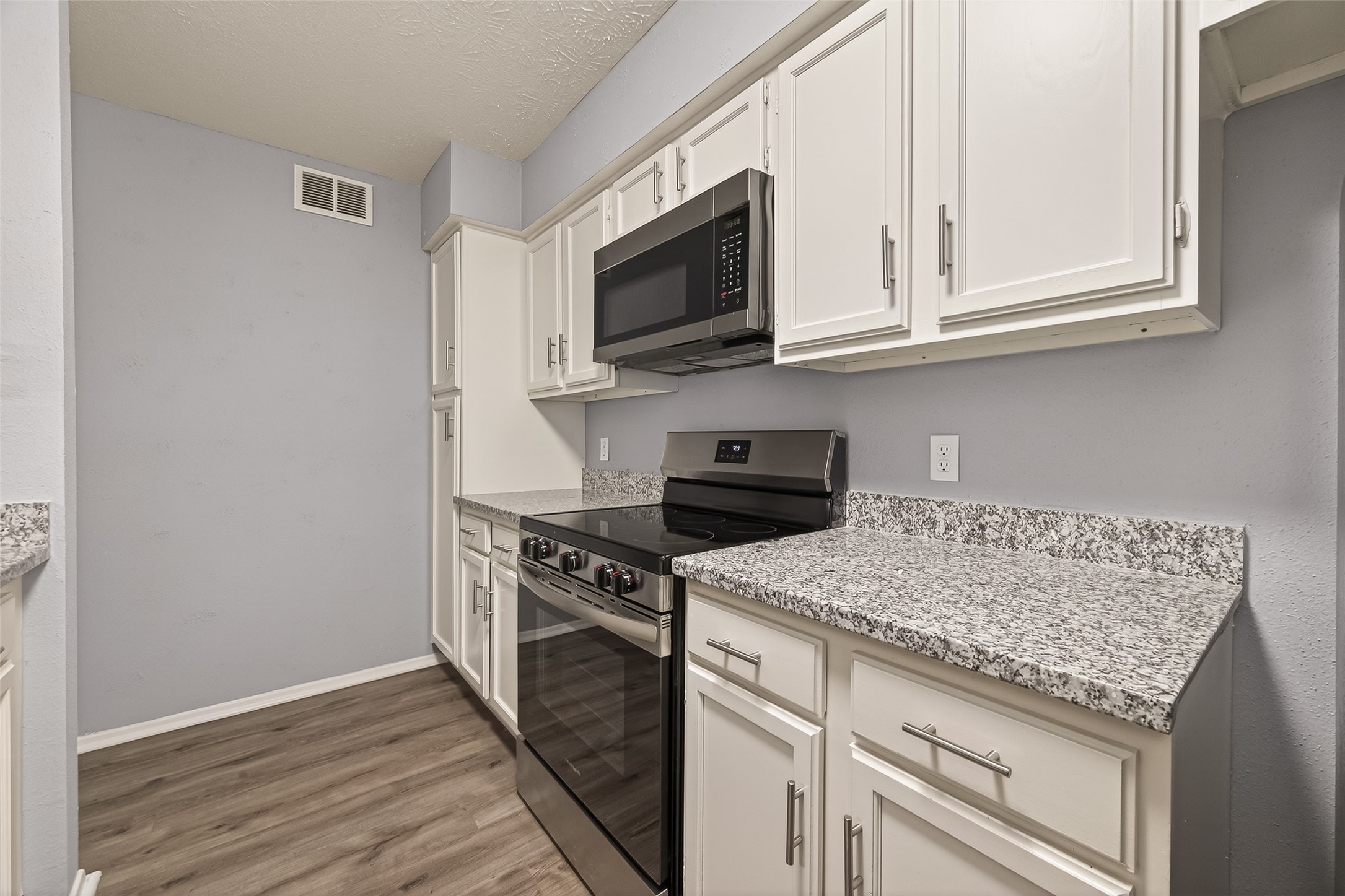 7313 Gulf Freeway, Unit 904 Houston, TX 77017 - Photo 17 of 27 a kitchen with stainless steel appliances granite countertop a stove and a microwave