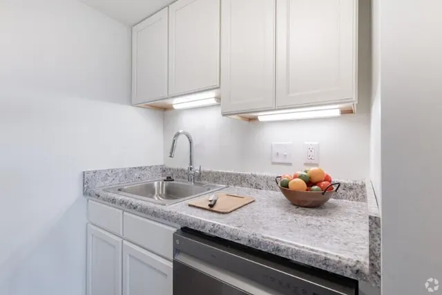 a kitchen with white cabinets and a sink