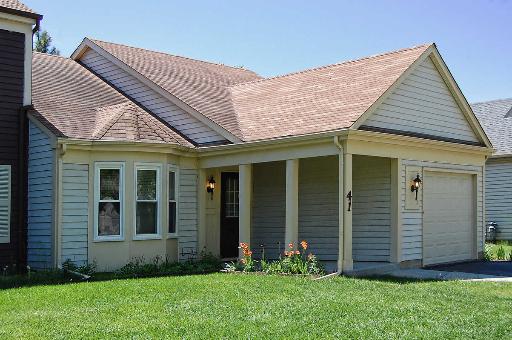 a view of a house with a yard potted plants and wooden fence
