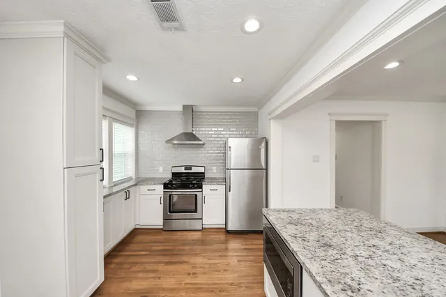 a kitchen with granite countertop wooden cabinets and stainless steel appliances