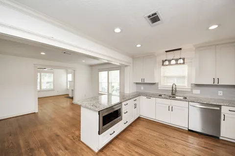 a kitchen with granite countertop a sink and wooden floor