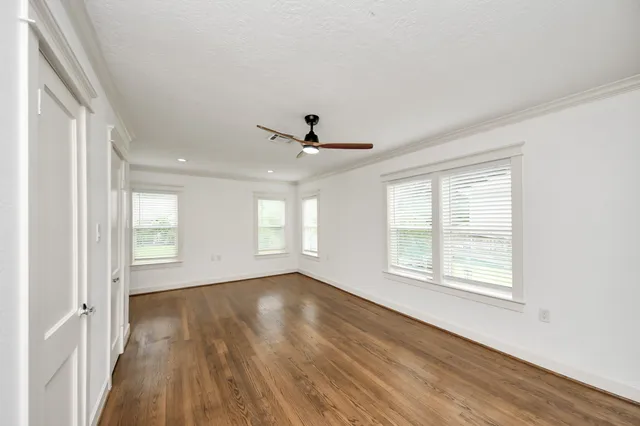 a view of a livingroom with wooden floor and a ceiling fan