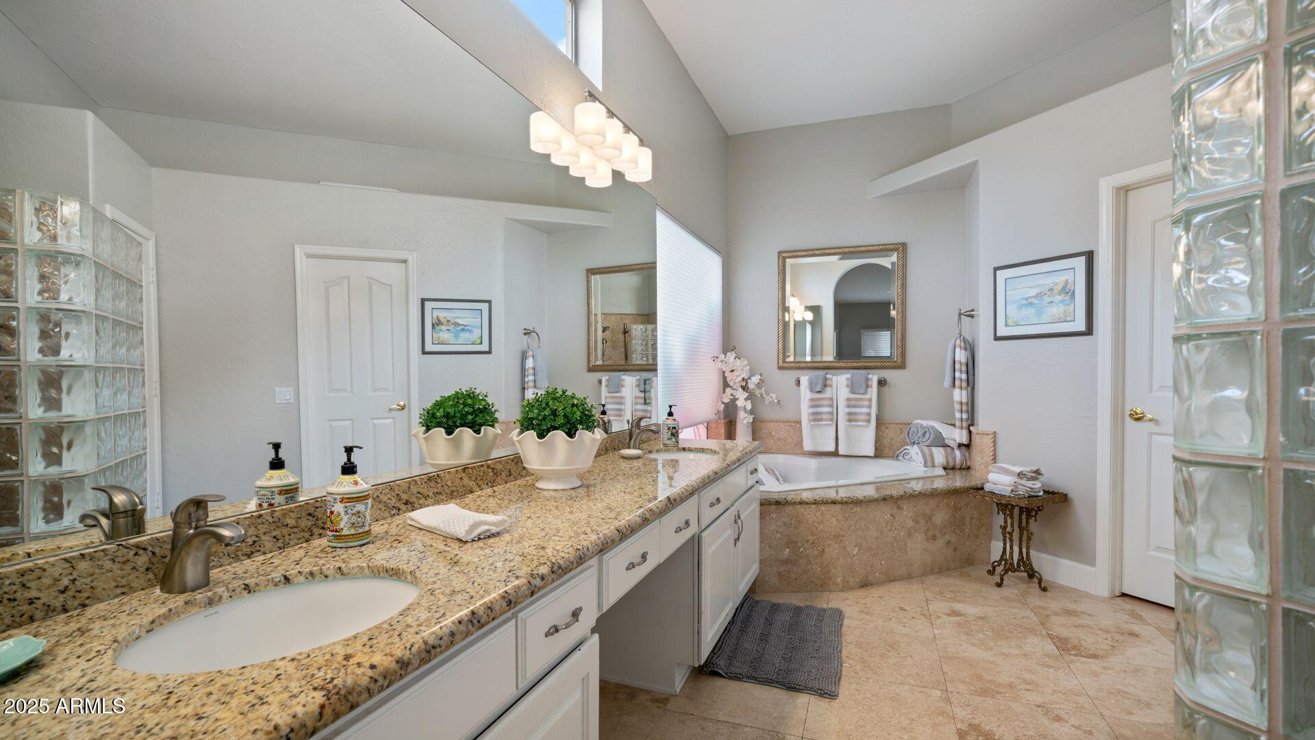 2214 East Beachcomber Drive Gilbert, AZ 85234 - Photo 17 of 45 a bathroom with a granite countertop sink a mirror and a shower