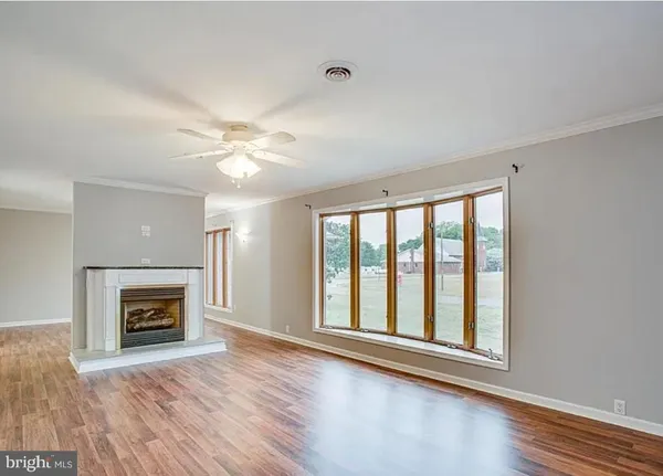 wooden floor fireplace and windows in an empty room
