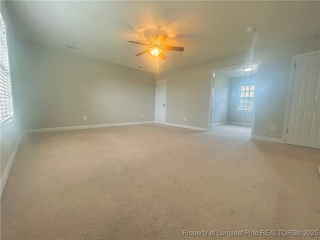 831 Northview Drive Sanford, NC 27332 - Photo 20 of 24 an empty room with a chandelier fan and windows