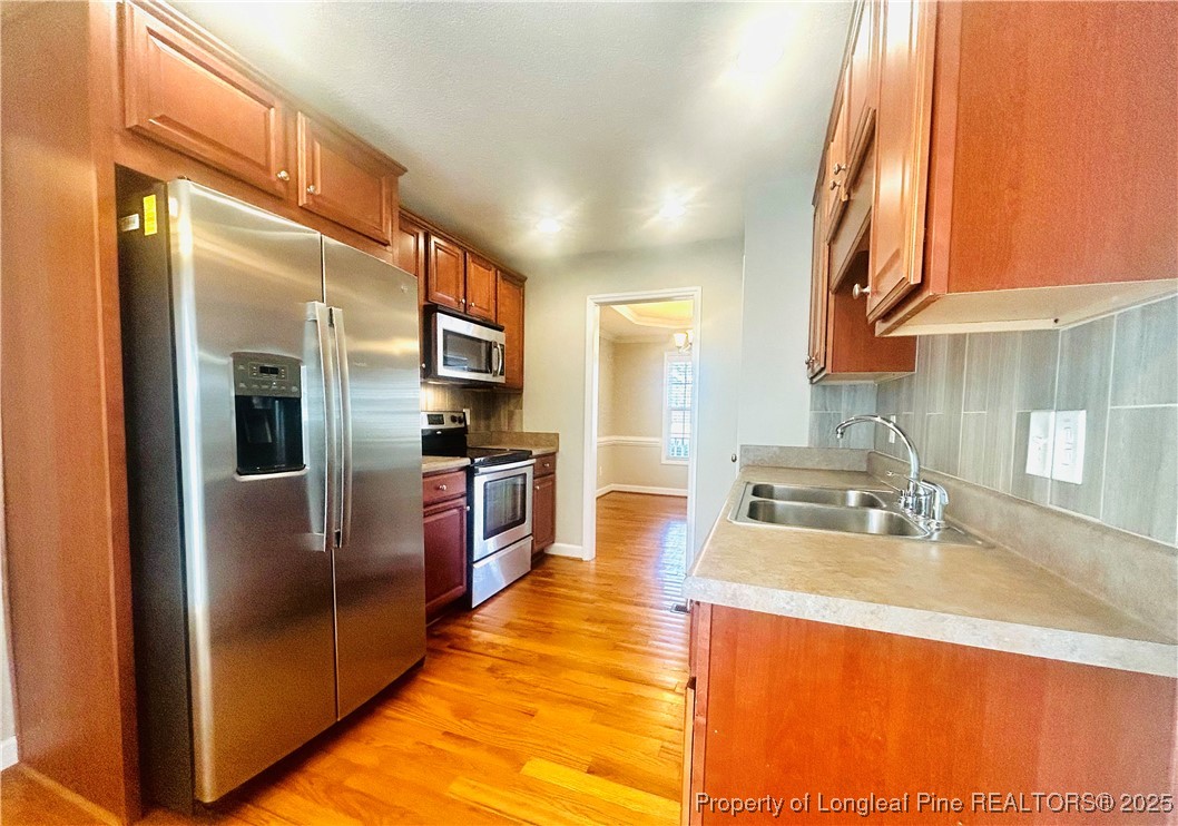 831 Northview Drive Sanford, NC 27332 - Photo 6 of 24 a kitchen with stainless steel appliances granite countertop a refrigerator a stove and a sink with wooden floor