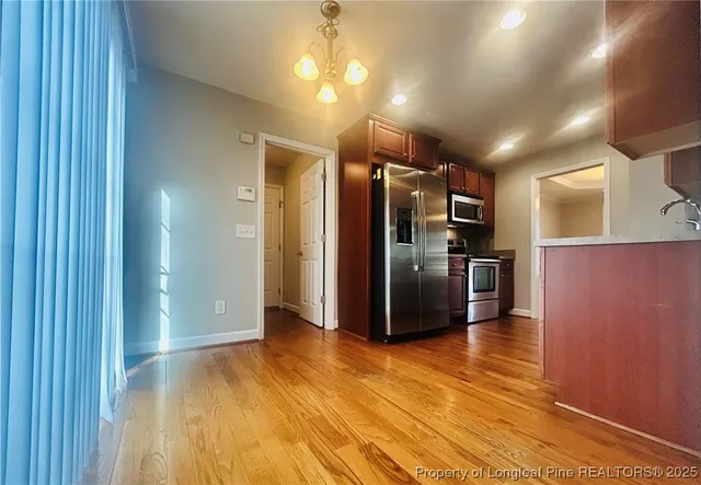 a kitchen with stainless steel appliances a refrigerator and wooden floor