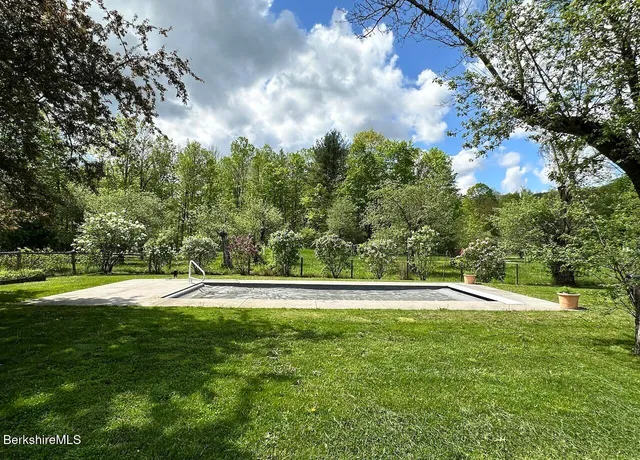 a yard with lots of green space and trees