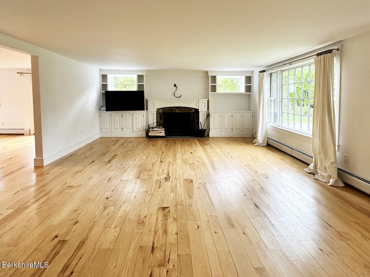1786 South Undermountain Road Sheffield, MA 01257 - Photo 3 of 17 a view of empty room with a flat screen tv and a fireplace