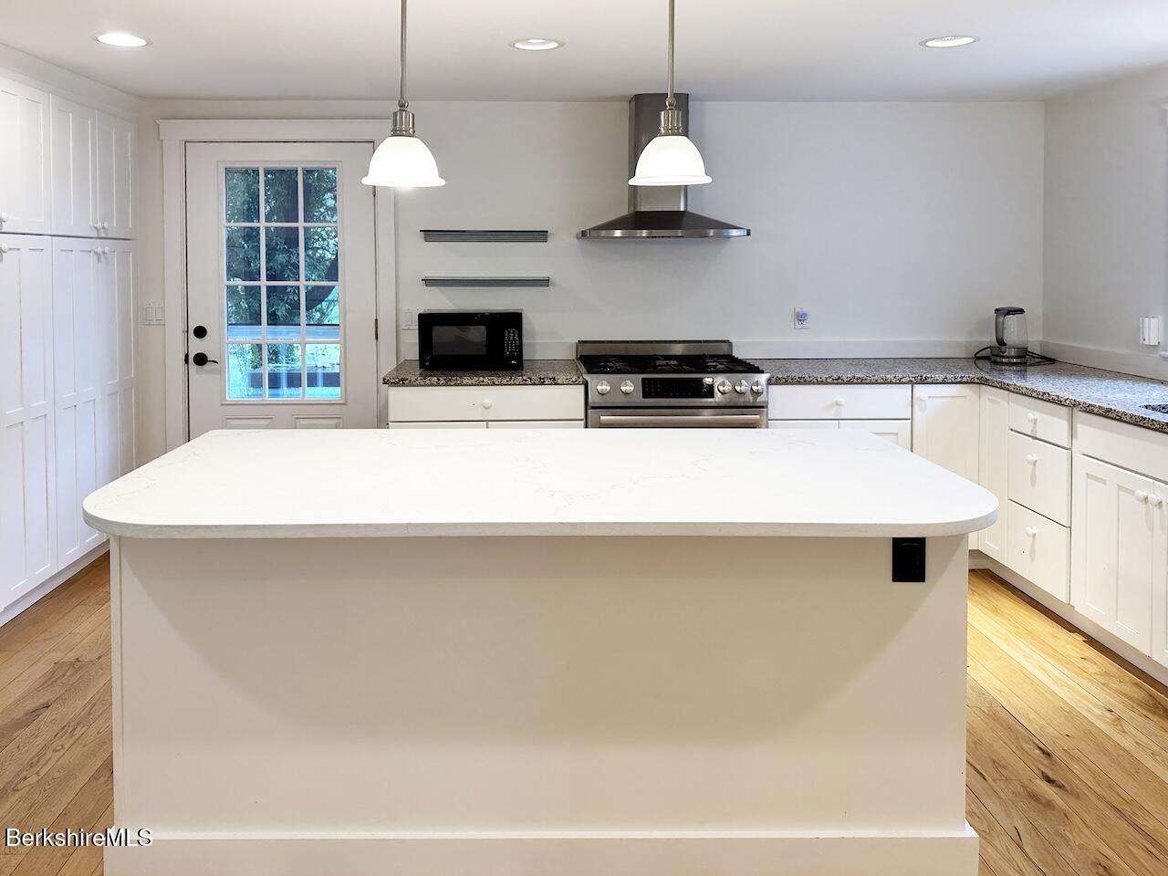 1786 South Undermountain Road Sheffield, MA 01257 - Photo 6 of 17 a kitchen with kitchen island granite countertop a stove a sink a center island and windows