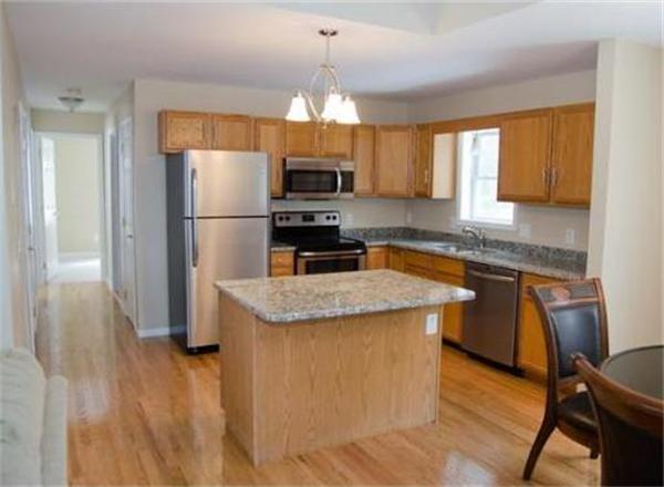 198 Ellis Road Westminster, MA 01473 - Photo 3 of 19 a kitchen with granite countertop a refrigerator a sink a stove a dining table and chairs