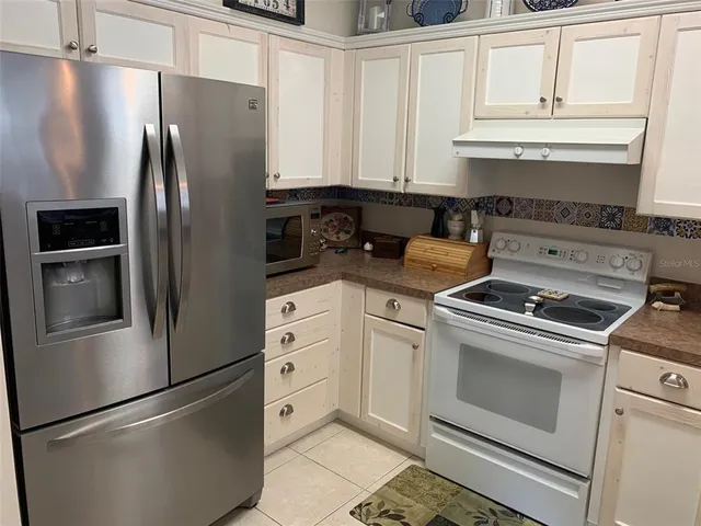 a kitchen with stainless steel appliances granite countertop a refrigerator sink and stove