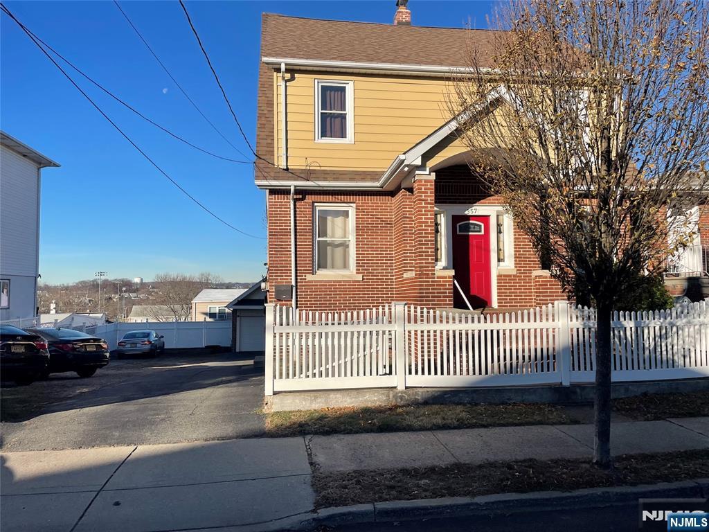 a view of a house with a small yard and wooden fence