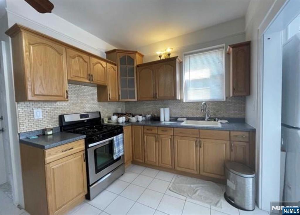 357 MacArthur Avenue, Unit 1 Garfield, NJ 07026 - Photo 7 of 11 a kitchen with a sink stove and cabinets