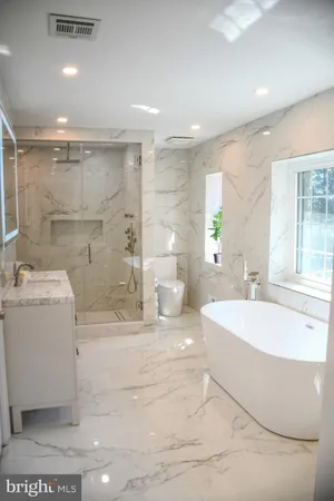 a large spacious bathroom with a tub a sink and a large mirror