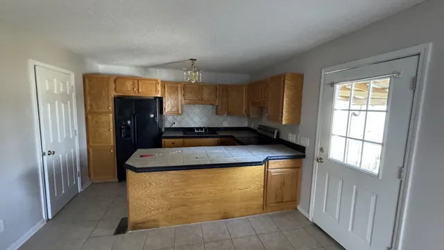 a kitchen with a refrigerator a sink and a window