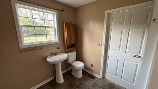 a bathroom with a toilet sink and a mirror