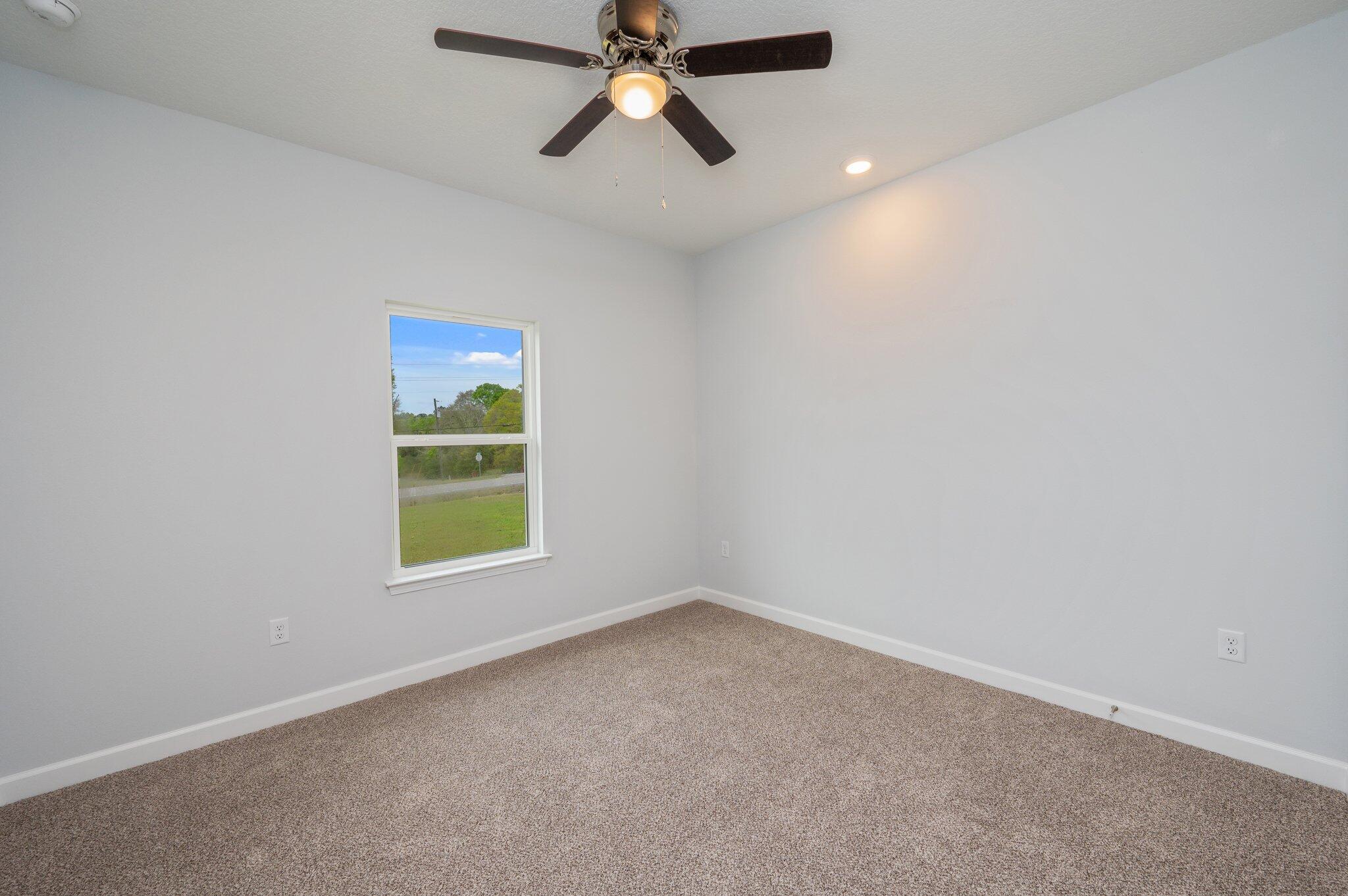 4071 Happy Trails Road Crestview, FL 32539 - Photo 22 of 35 an empty room with a window and a ceiling fan